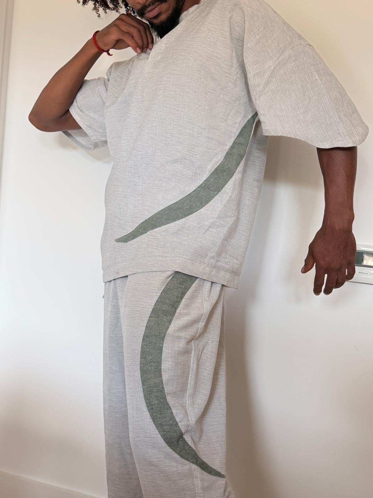 Person wearing the pale grey Concrete Jungle Vines top and trousers with curved sage details
