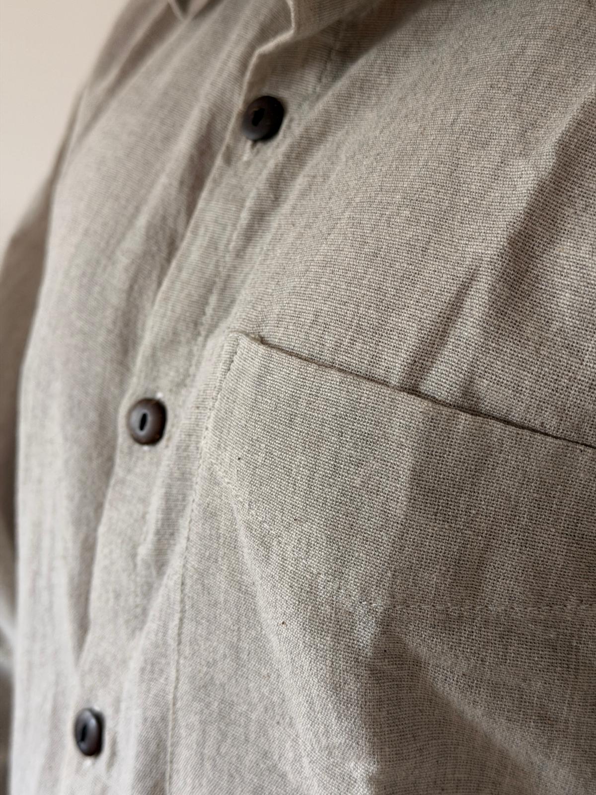 Close view of the summer suit's warm stone weave, buttons and chest pocket