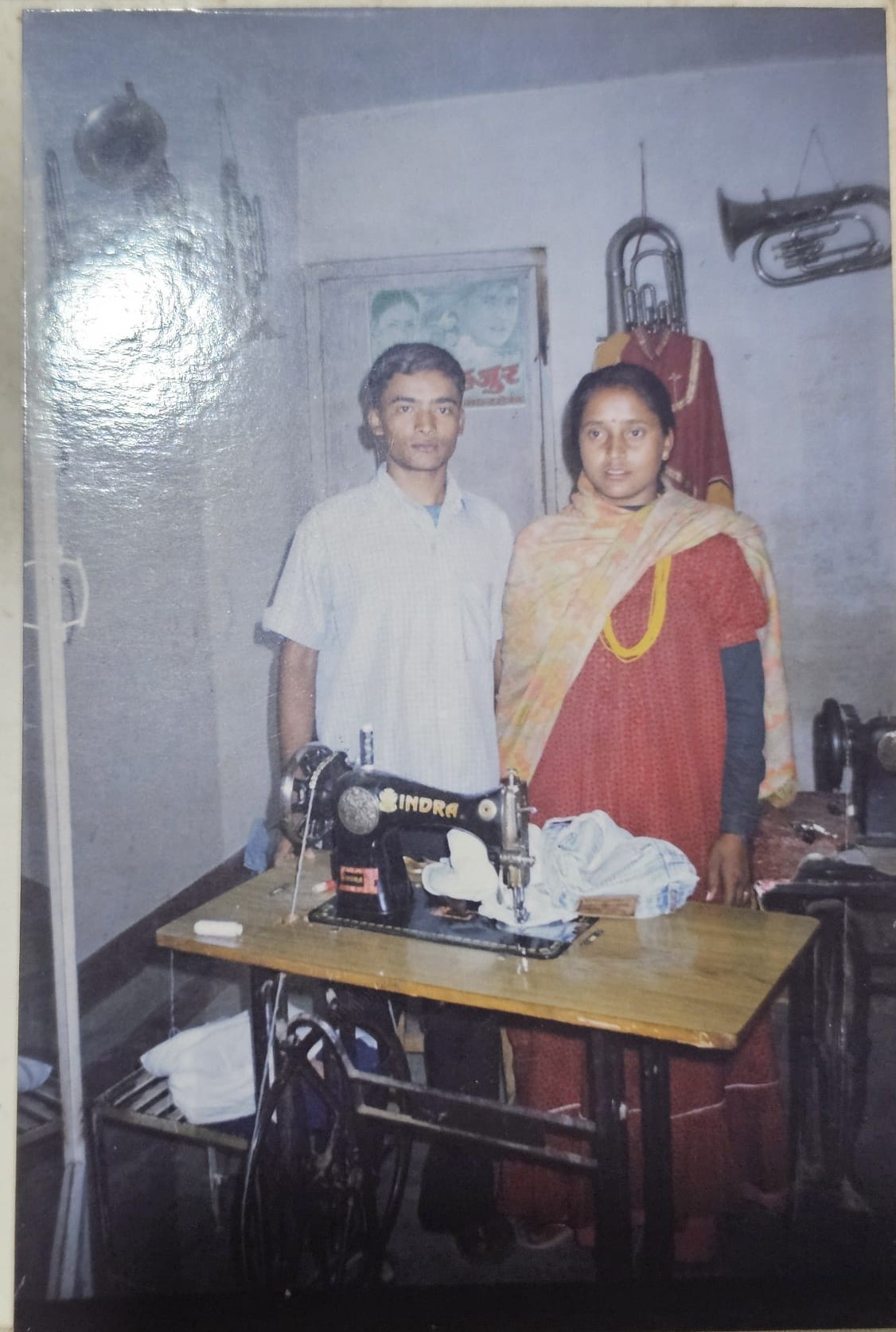 Dipesh Pariyar's parents in their Kathmandu tailoring room with their first sewing machine